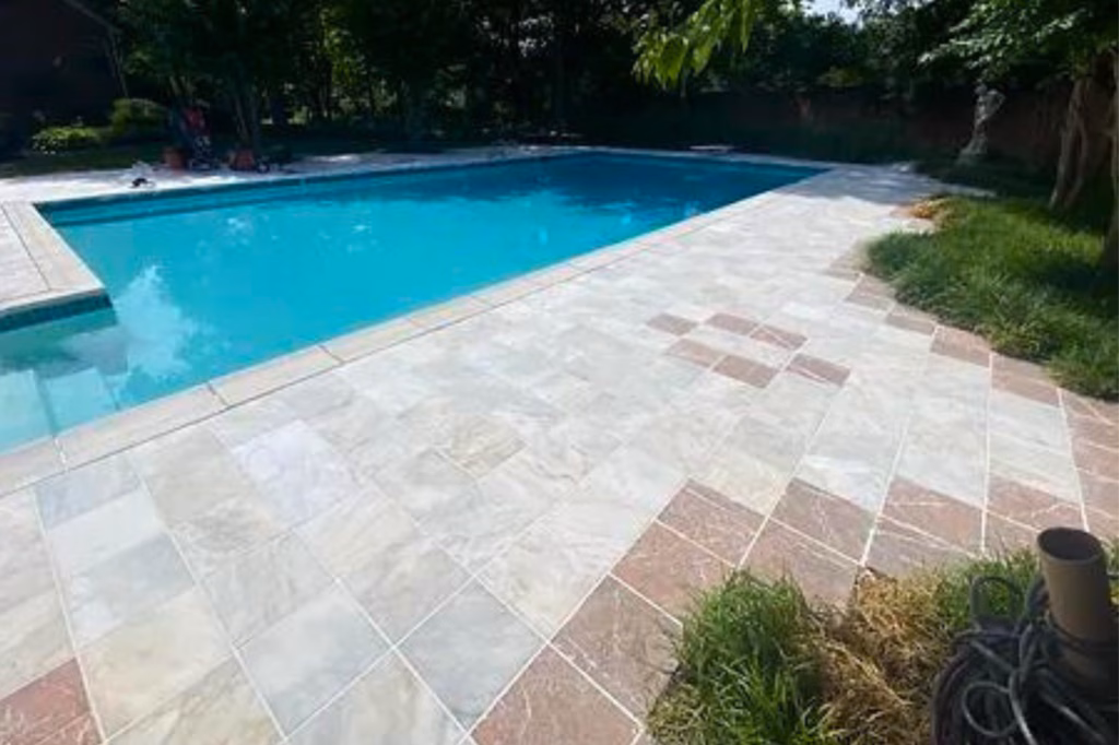 Restored stone pool deck beside a residential pool