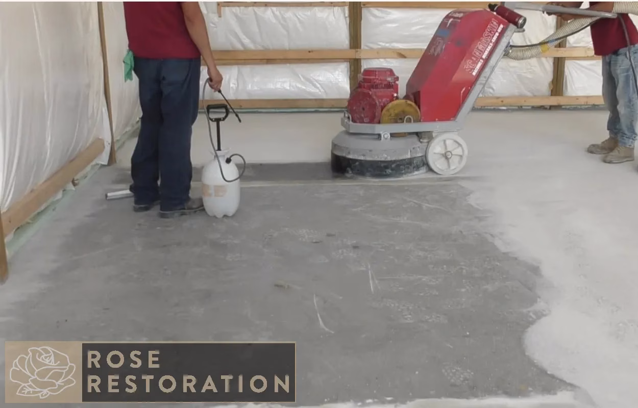 Concrete grinding machine preparing garage floor surface for epoxy coating