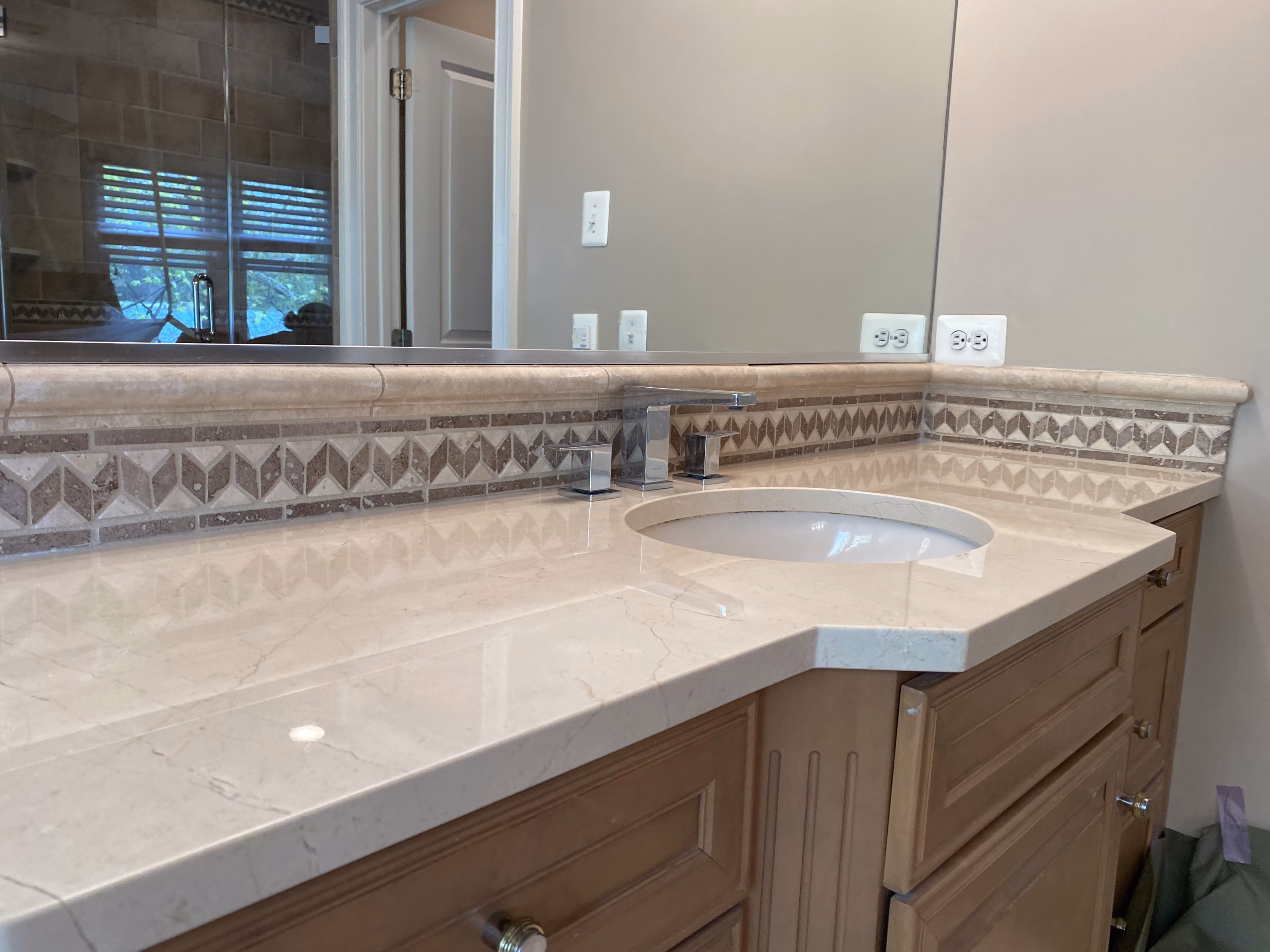 Restored marble bathroom vanity top with a decorative mosaic tile border