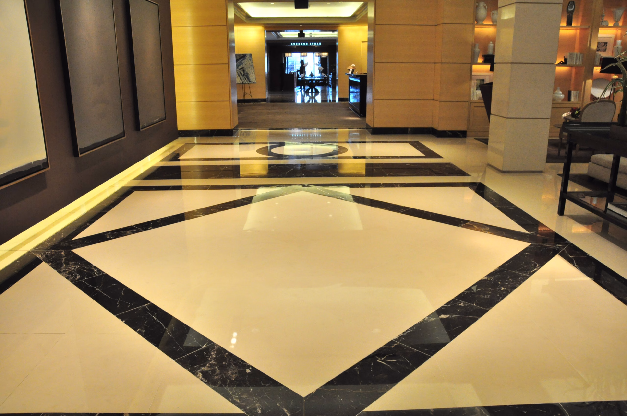 Polished marble lobby floor with a black stone diamond border, restored by Rose Restoration