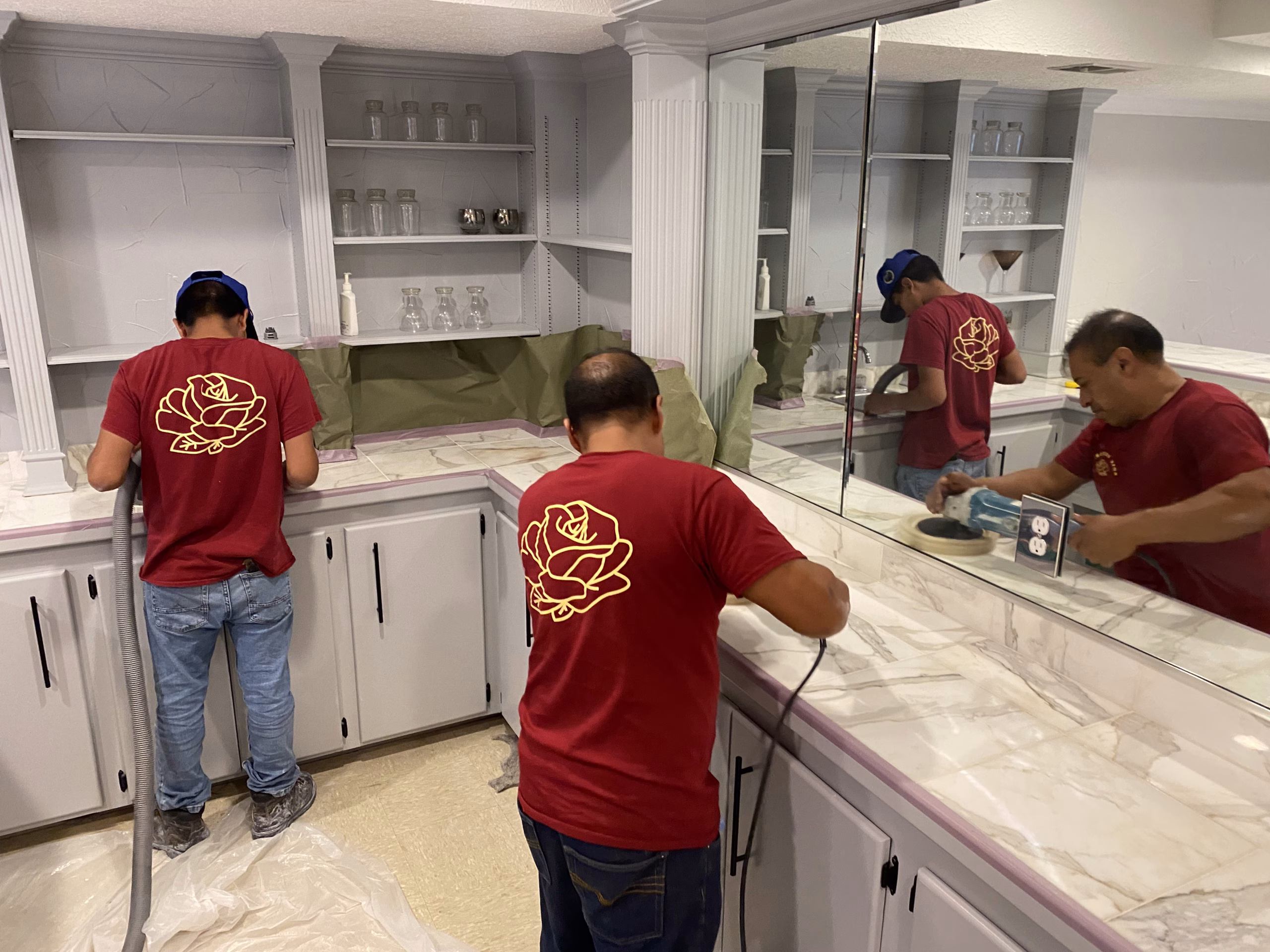 Rose Restoration technicians polishing a stone countertop in a residential kitchen