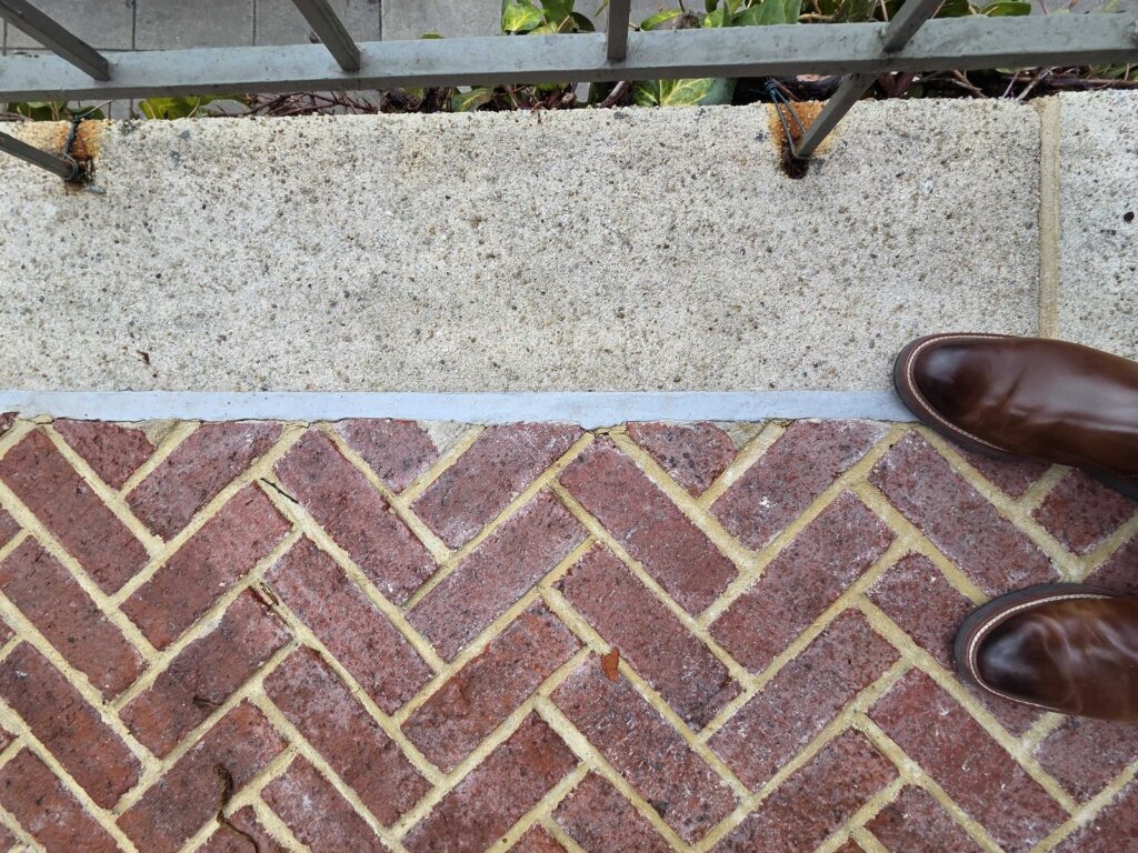 Commercial exterior brick paver patio with concrete showing efflorescence white residue