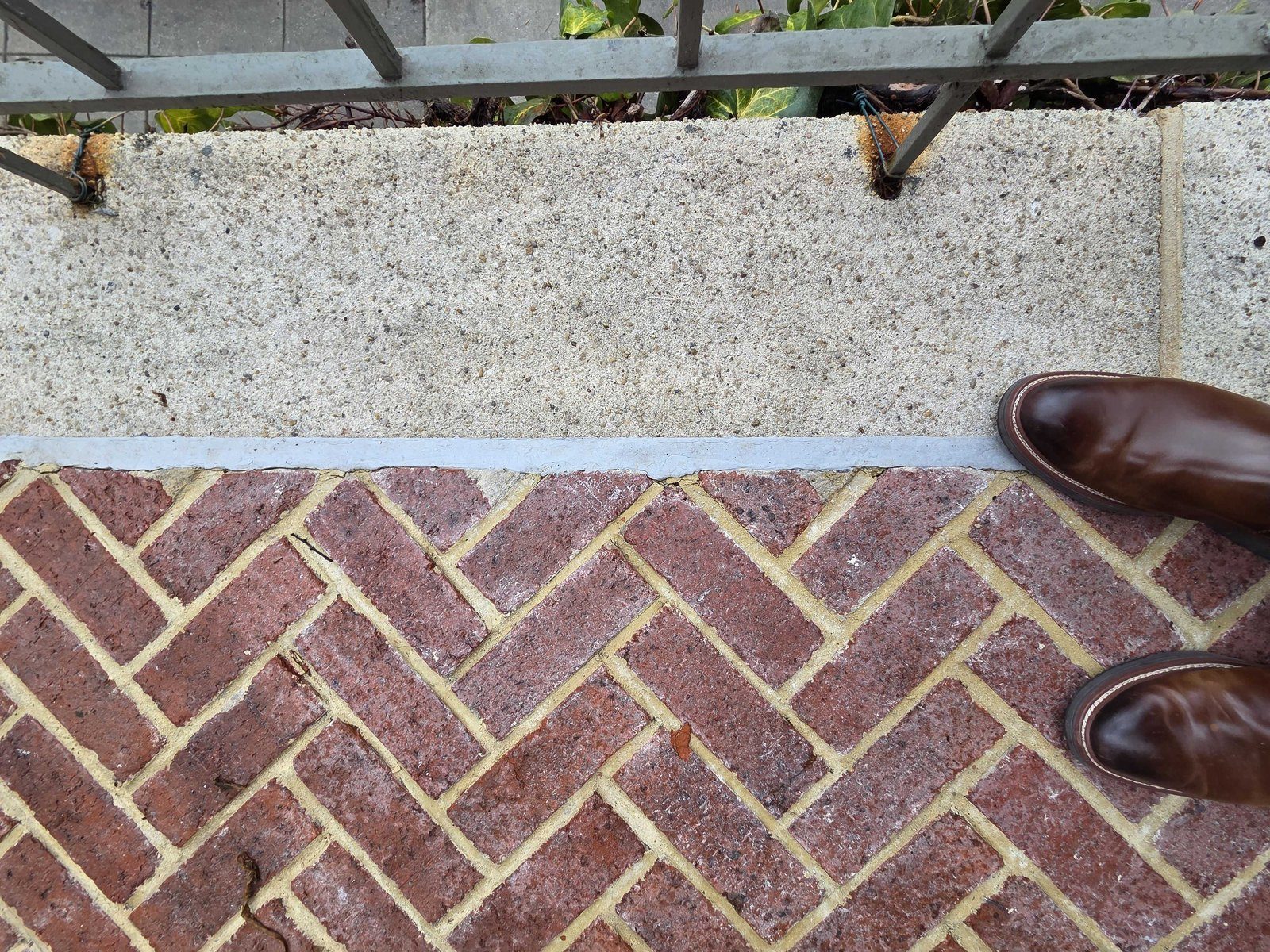 Commercial exterior brick paver patio with concrete showing efflorescence white residue