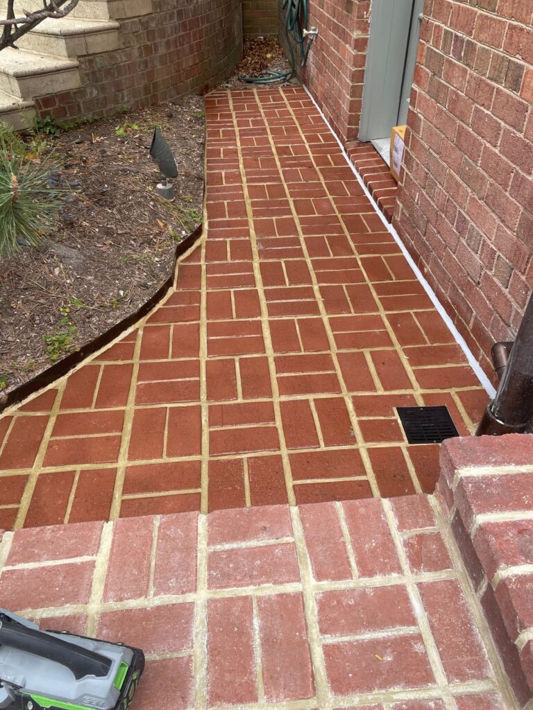 Brick walkway and patio path repointing in progress by Rose Restoration masonry crew
