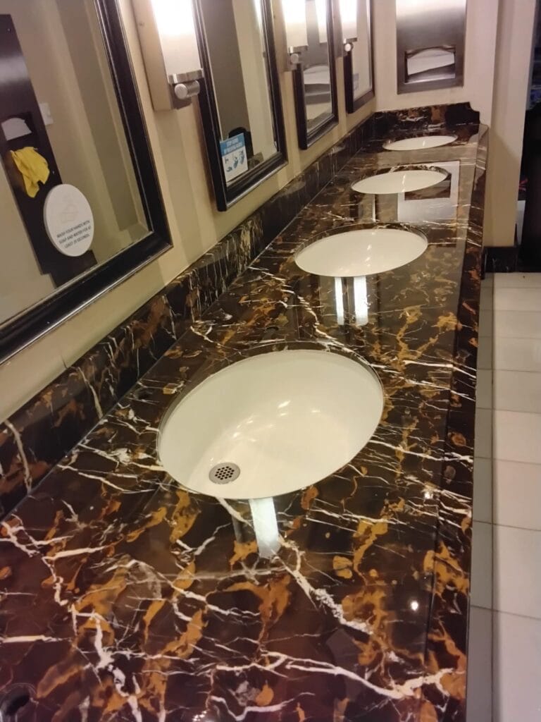 Polished dark marble vanity with undermount sinks