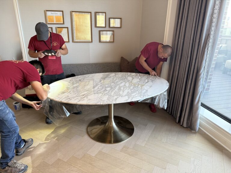 Marble dining table with etch marks being restored by Rose Restoration technician