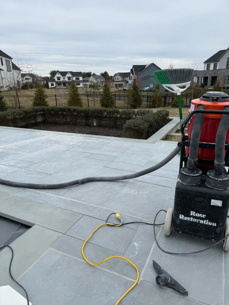 Residential stone patio being sealed by Rose Restoration team