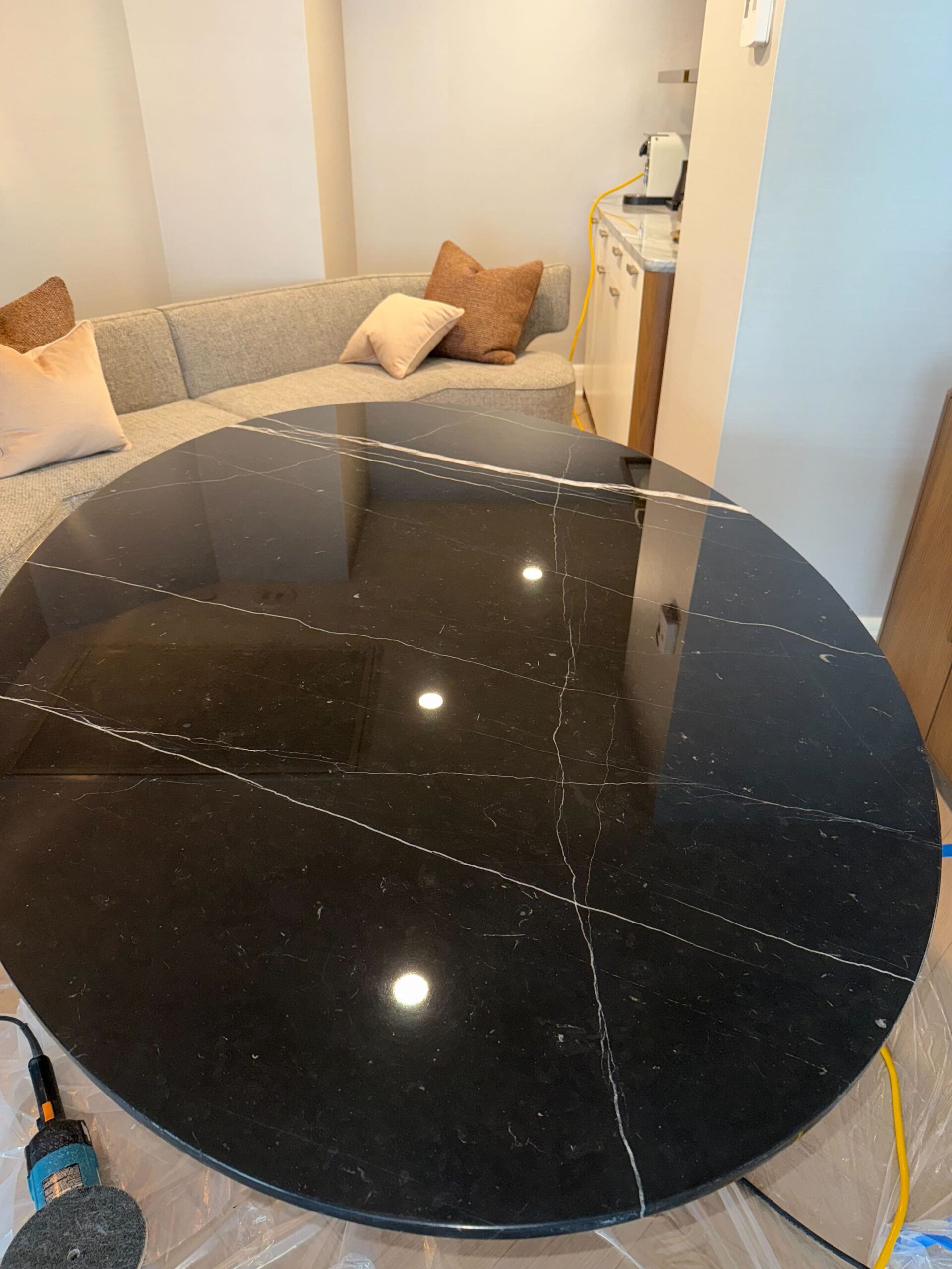 Black marble table restoration in progress showing polishing technique by Rose Restoration