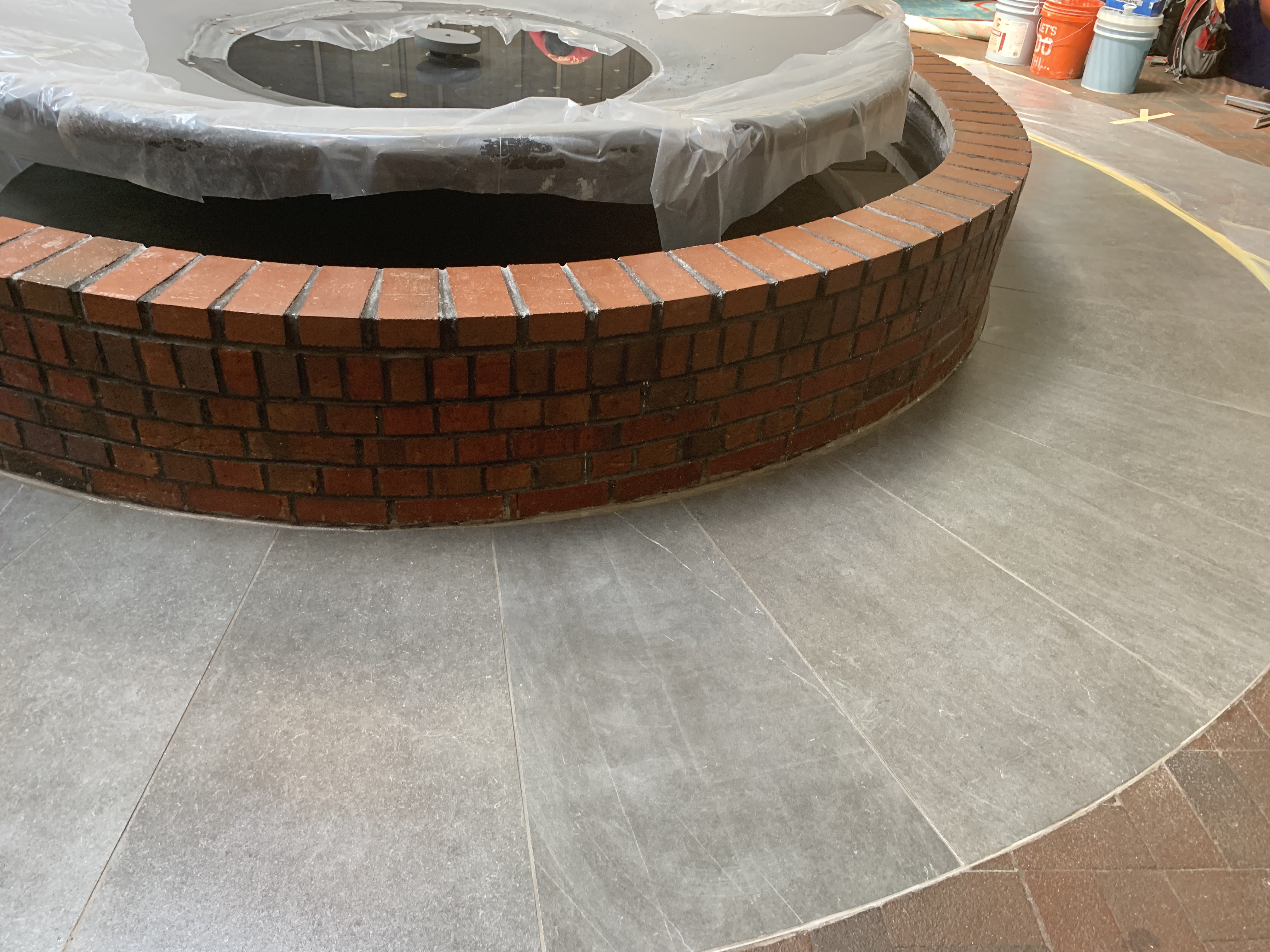 Outdoor polished concrete with brick fountain by Rose Restoration