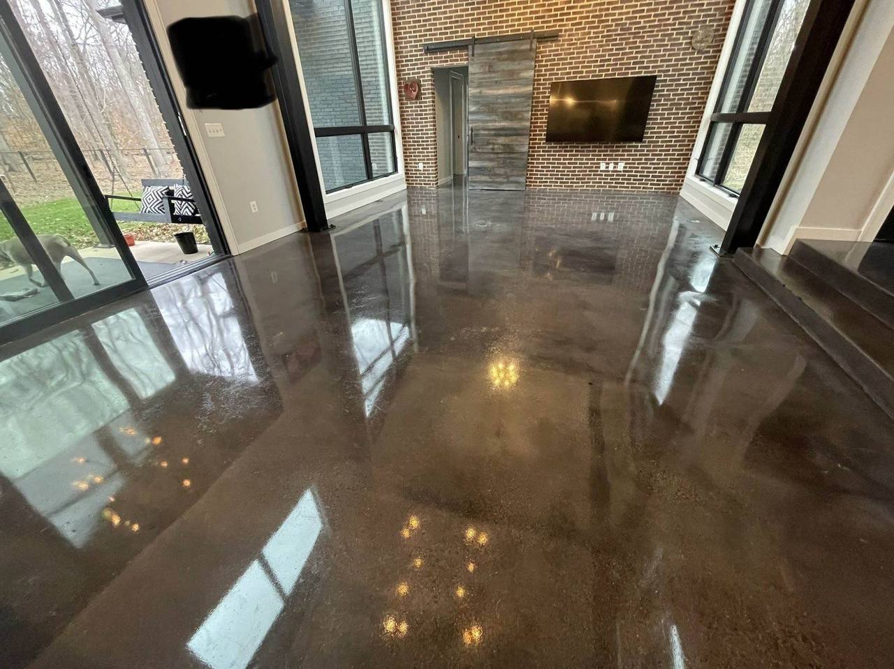 Stained and polished concrete floor with warm reflections in a commercial interior by Rose Restoration
