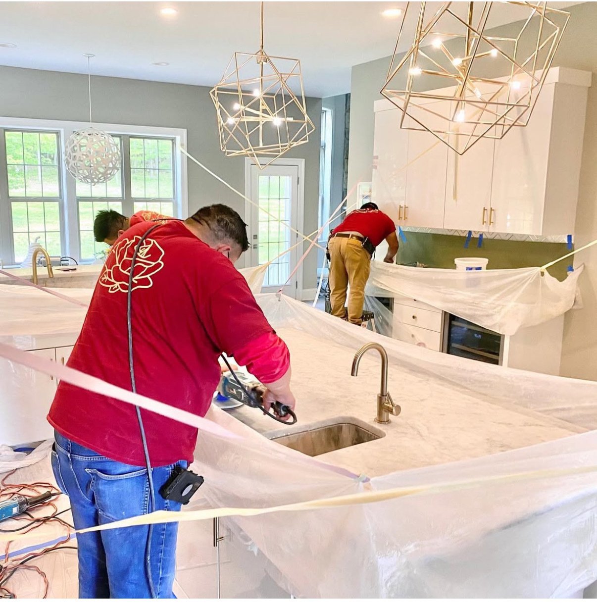 Rose Restoration technicians polishing a white marble kitchen countertop