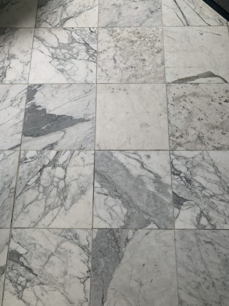 Close-up of polished white Carrara marble tile showing natural veining after restoration by Rose Restoration