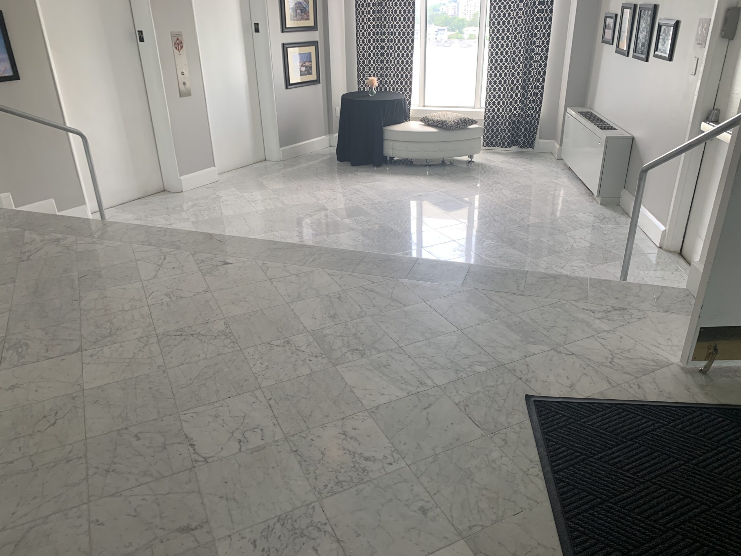 Polished Carrara marble elevator lobby floor showing mirror reflection after restoration by Rose Restoration