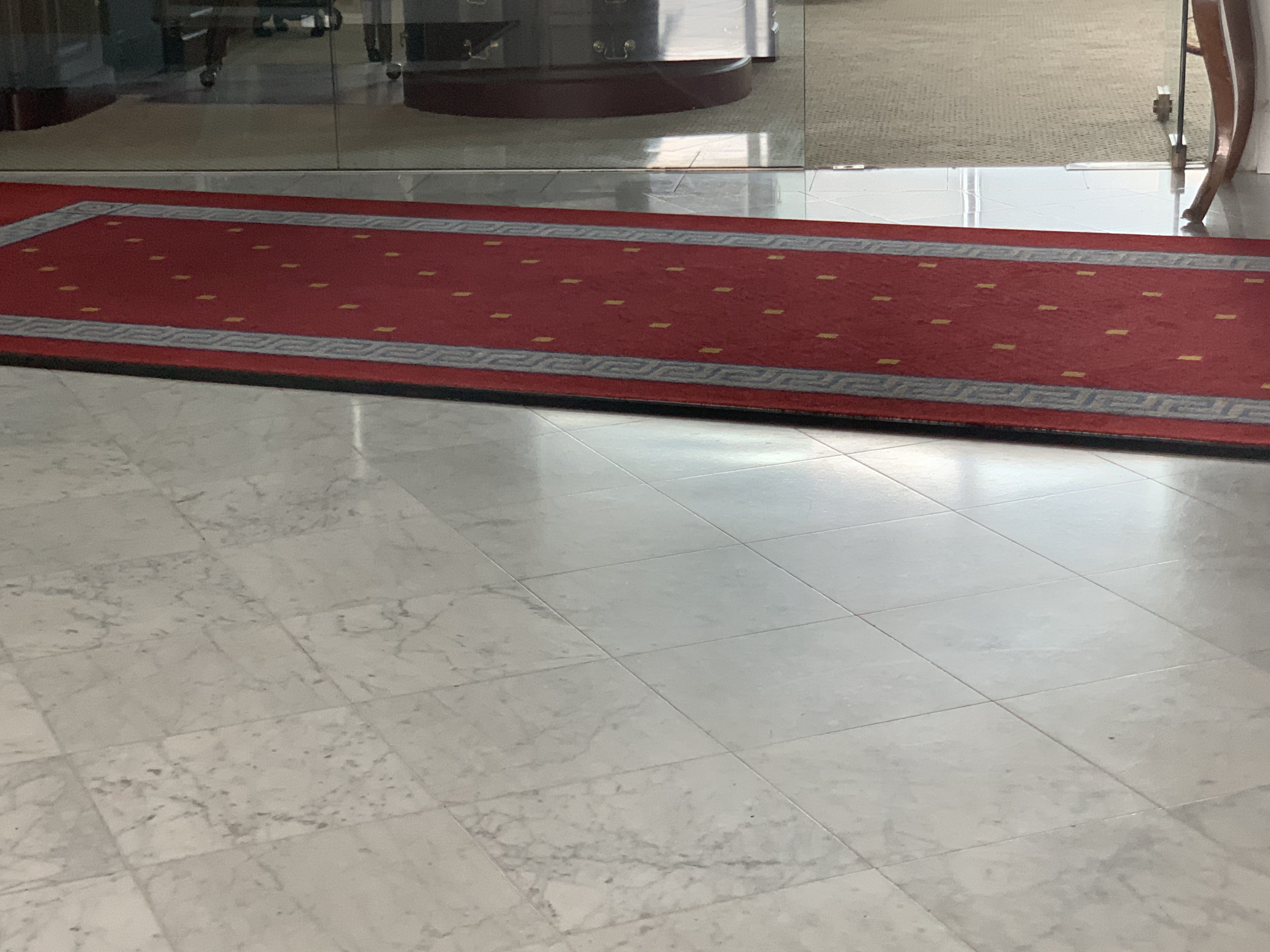 Polished marble entrance floor with a patterned runner leading through a restored lobby by Rose Restoration