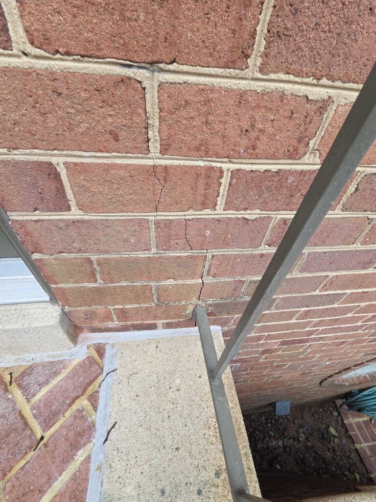 Residential exterior historic brick wall showing mortar degradation before restoration
