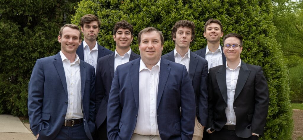 Seven Rose Restoration team members in business attire, photographed outdoors