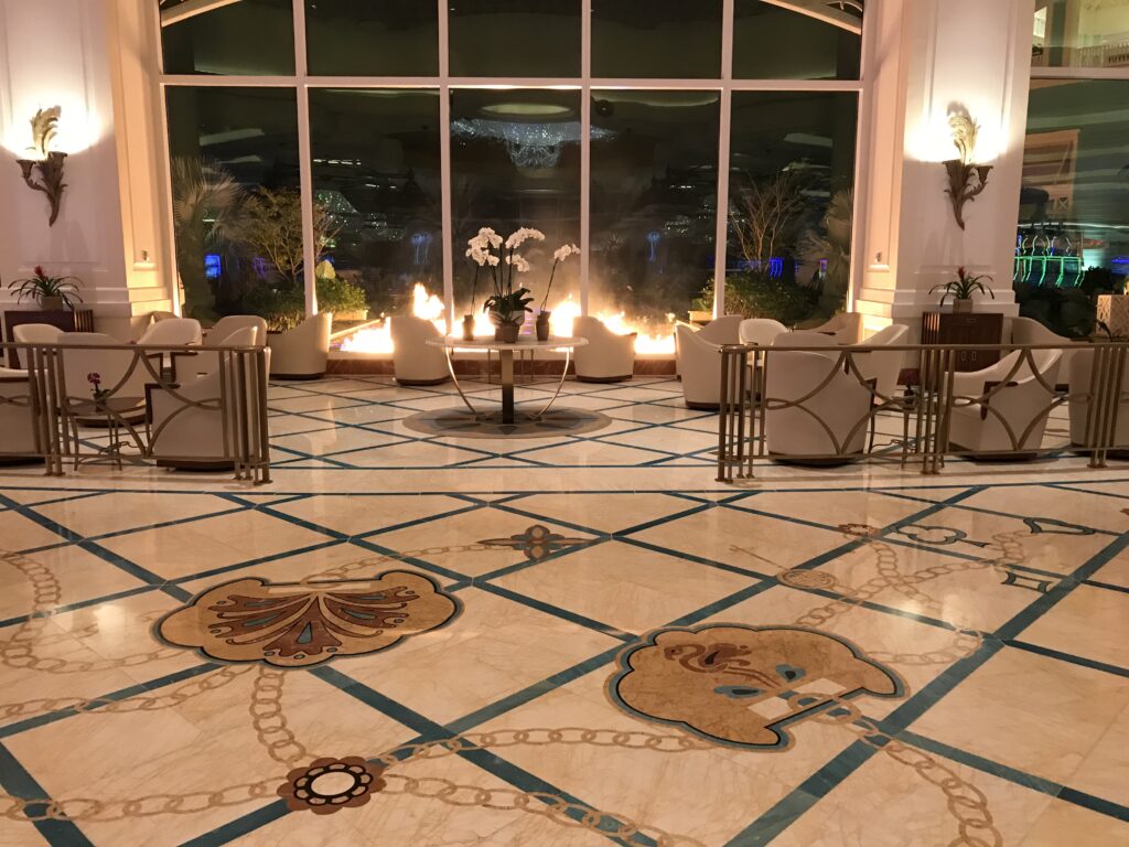 Polished marble lobby floor with decorative stone inlay and medallion detail, restored by Rose Restoration