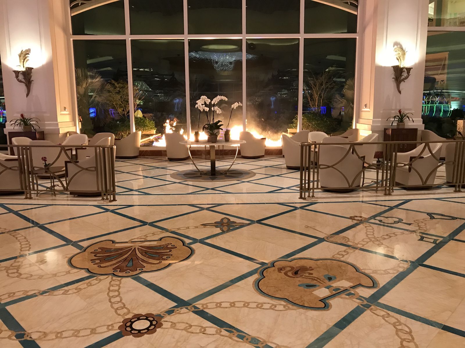 Baha Mar lobby seating and polished marble floor looking toward the window wall at dusk