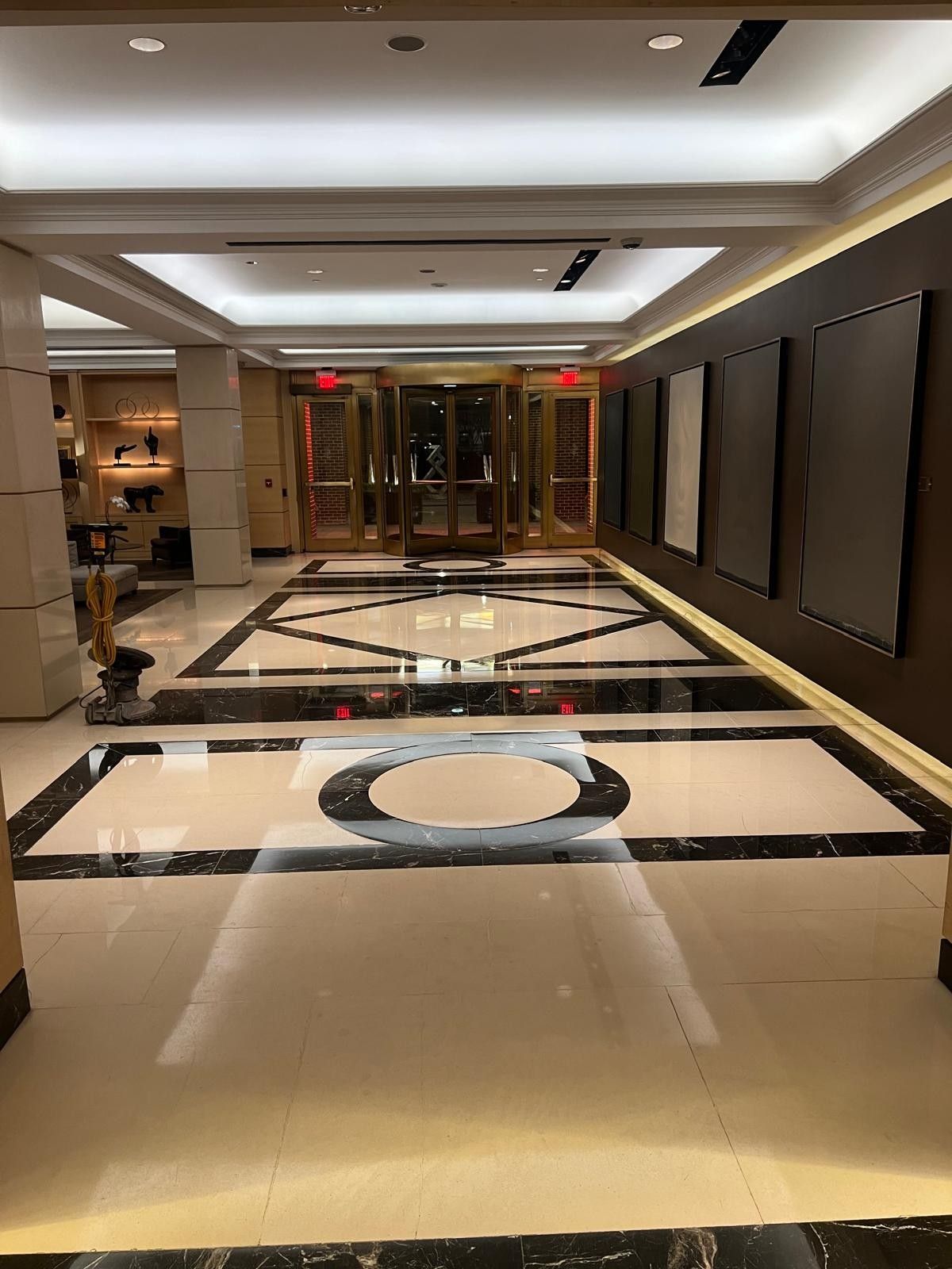 Polished marble elevator lobby floor with a black and white geometric medallion, restored by Rose Restoration