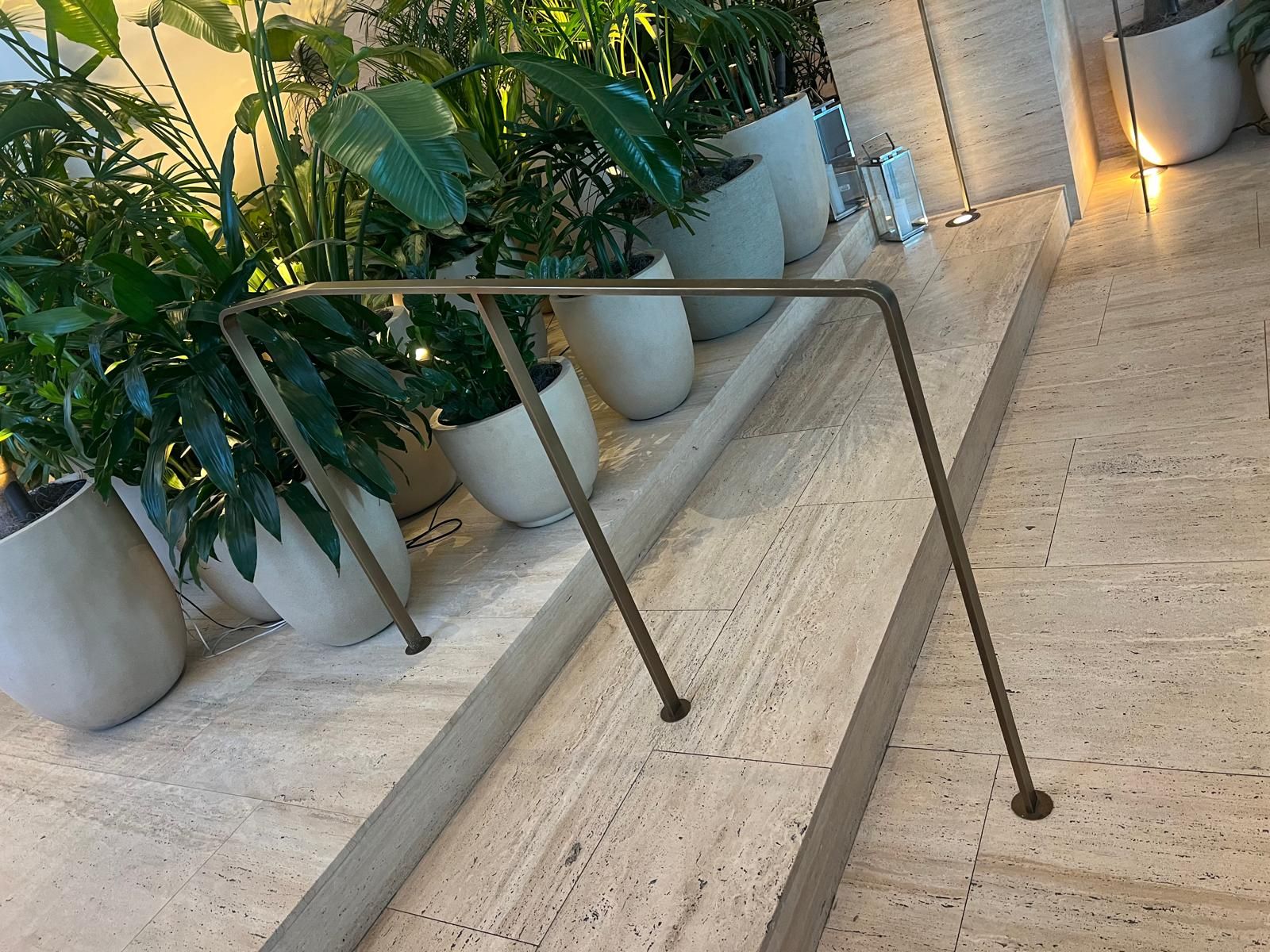 Restored stone entrance paving with planters and a brass handrail