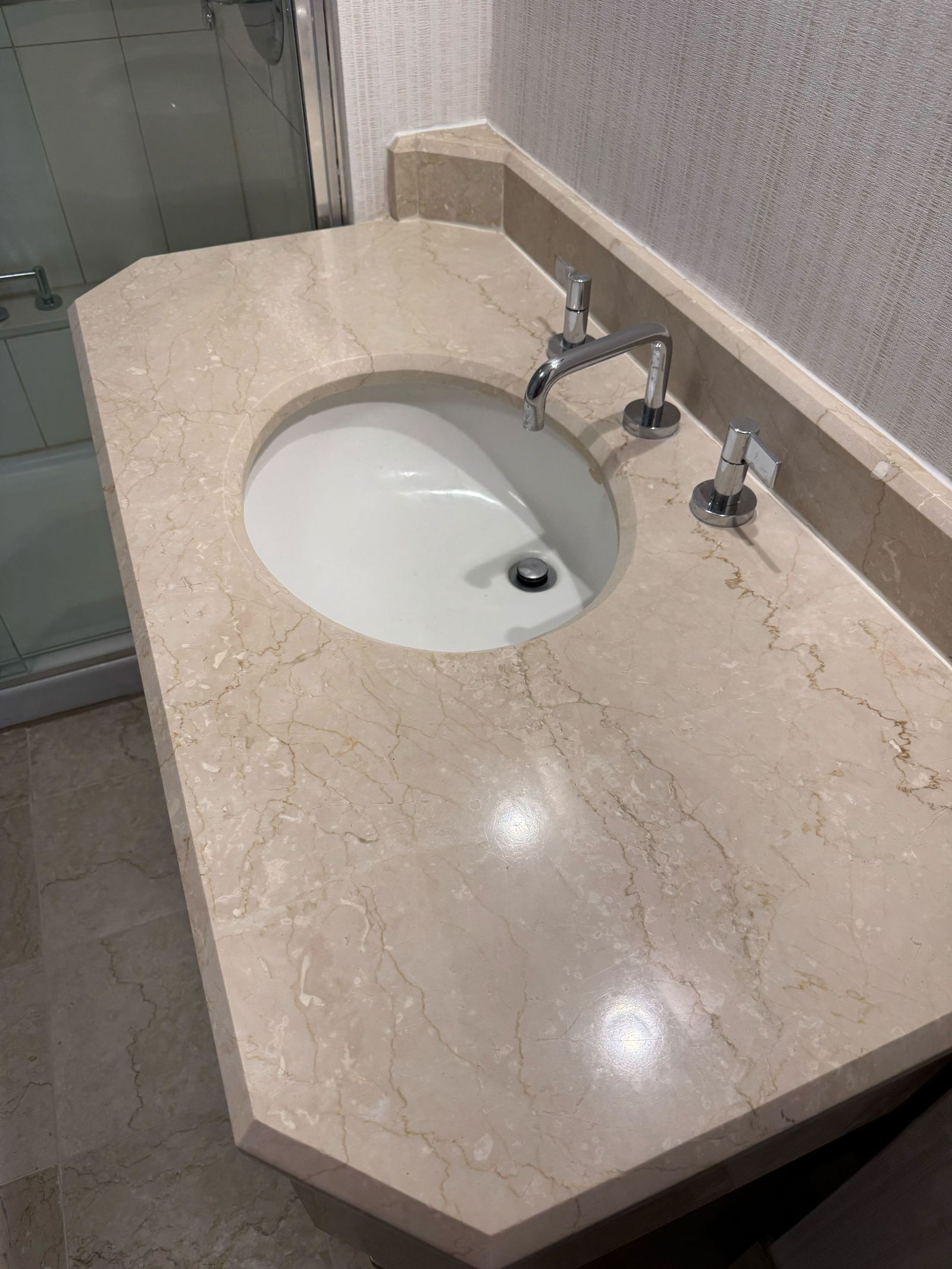 Polished marble vanity top in an Alexandria hotel guest bathroom restored by Rose Restoration