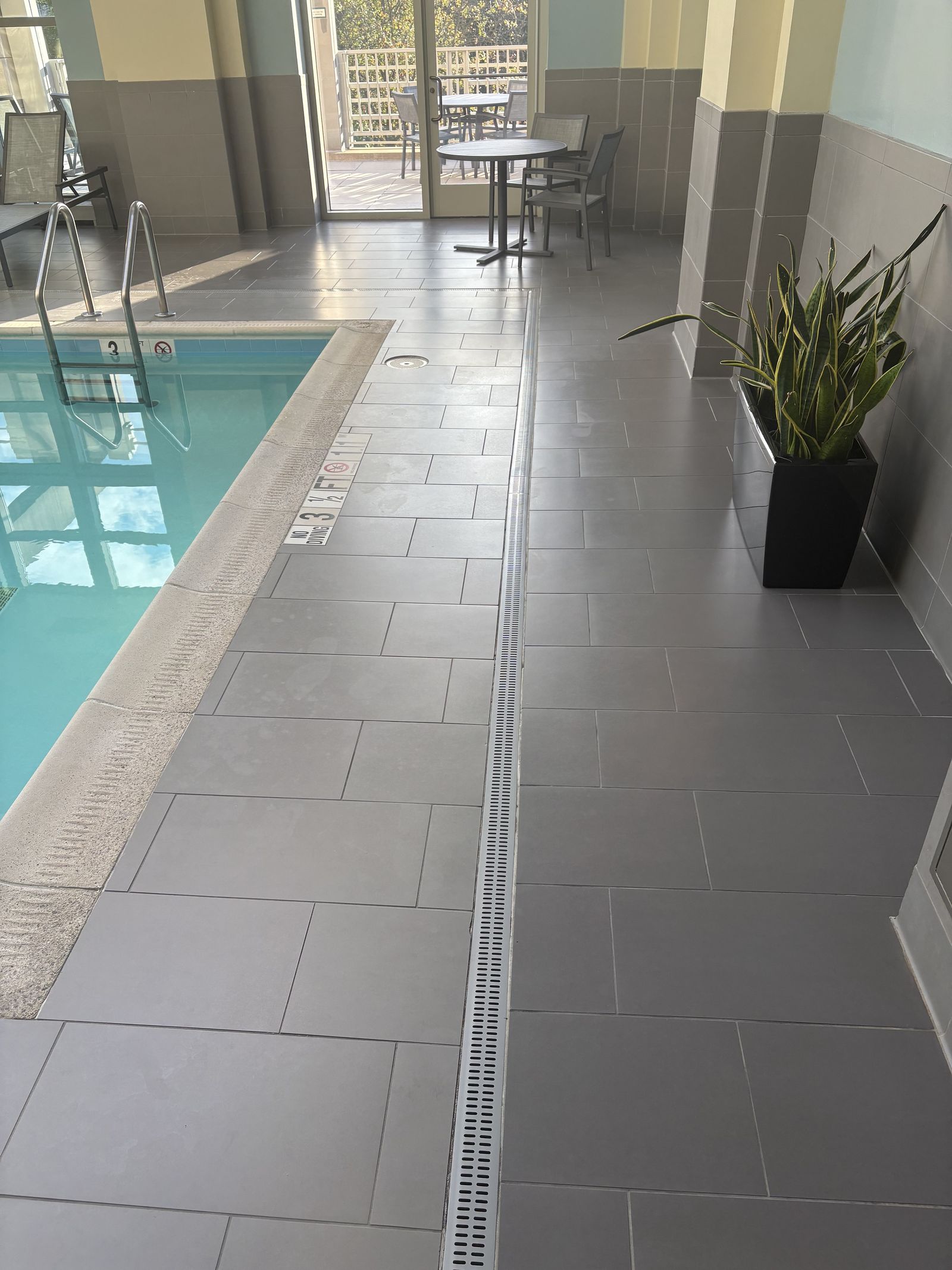 Tile terrace beside an indoor hotel pool in Reston, Fairfax County