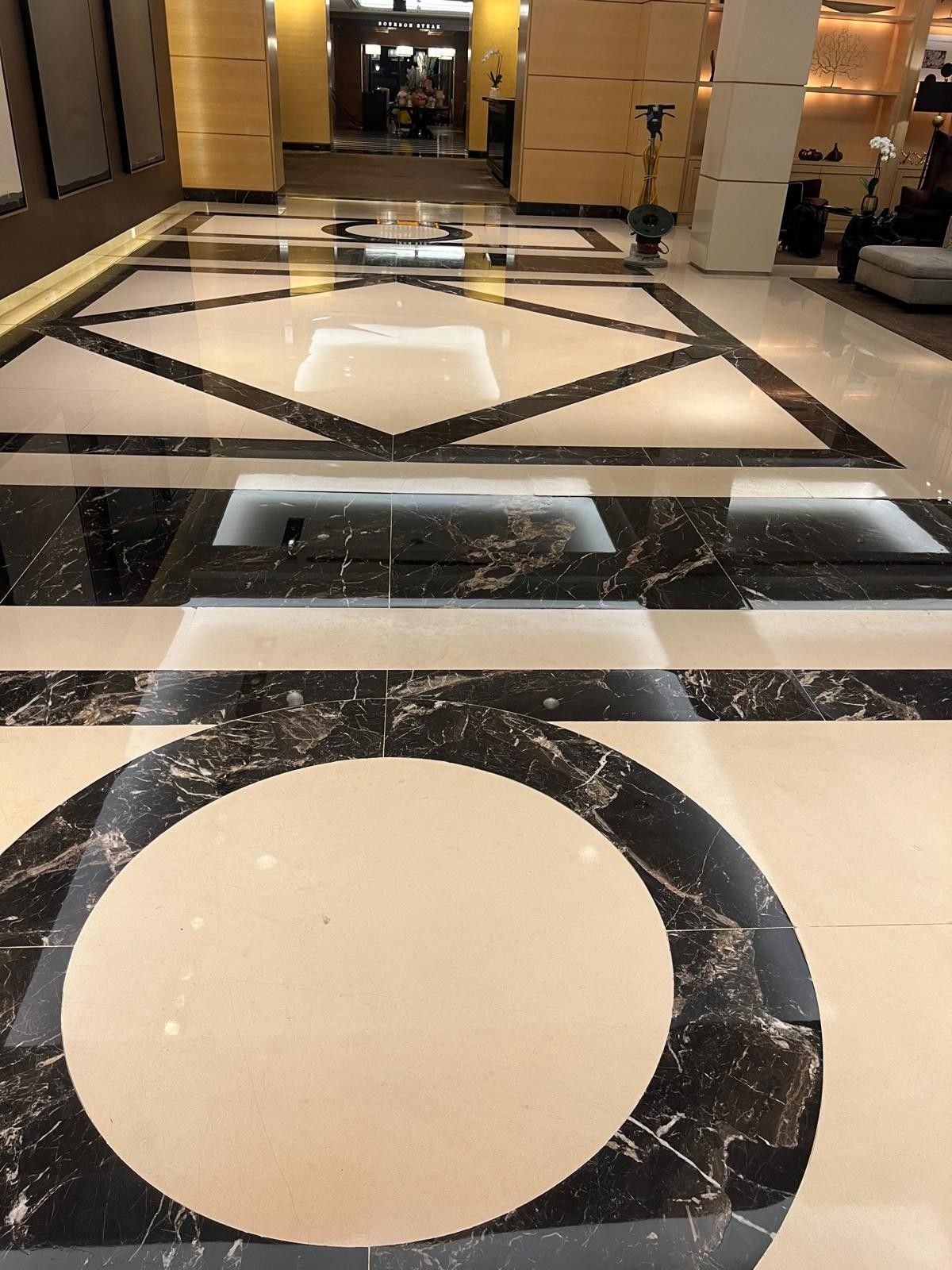 Detail of a black and white marble medallion inlay in a polished lobby floor, restored by Rose Restoration
