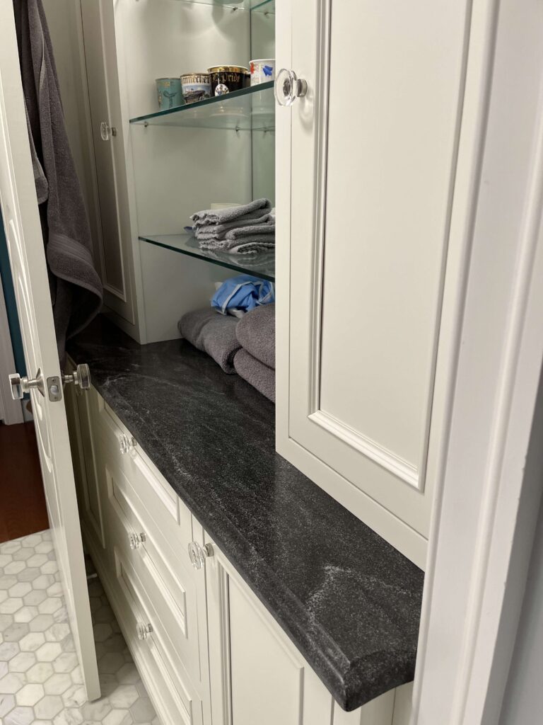 Black stone countertop with glass shelves from a Rose Restoration job in Arlington, VA