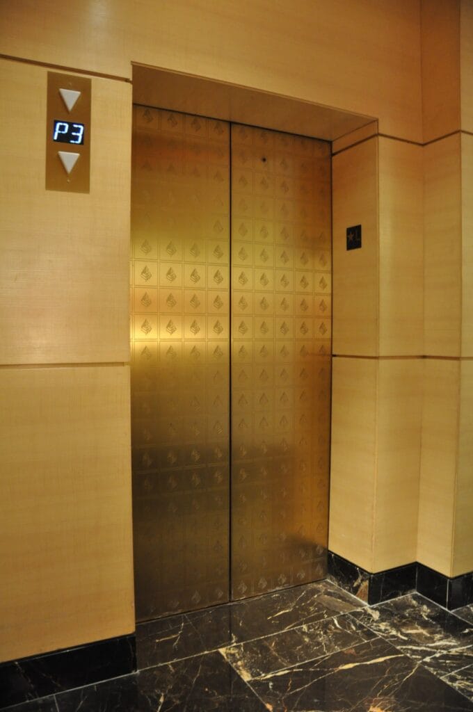 Brass elevator doors and a marble floor after polishing
