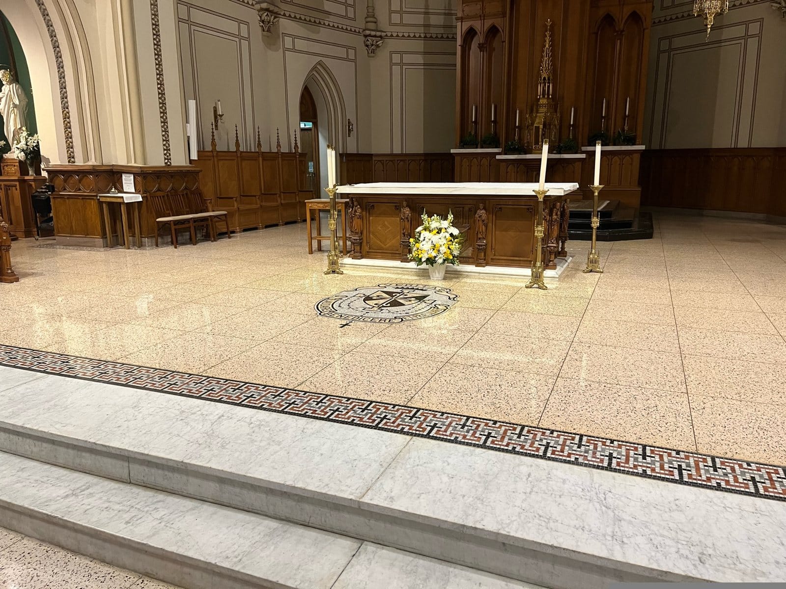 Polished terrazzo sanctuary floor with a Greek key border and marble altar steps in a Southwest DC Catholic church, restored by Rose Restoration