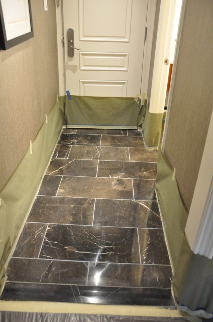Dark marble bathroom floor with protected walls during work