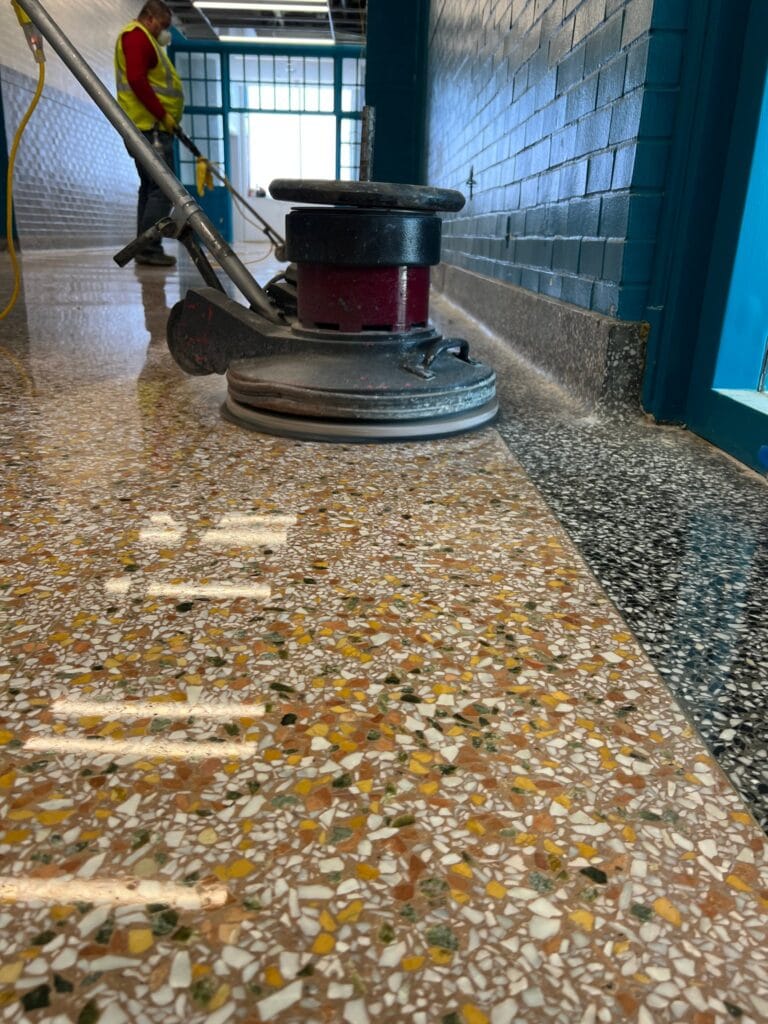Floor machine on a terrazzo corridor mid-polish