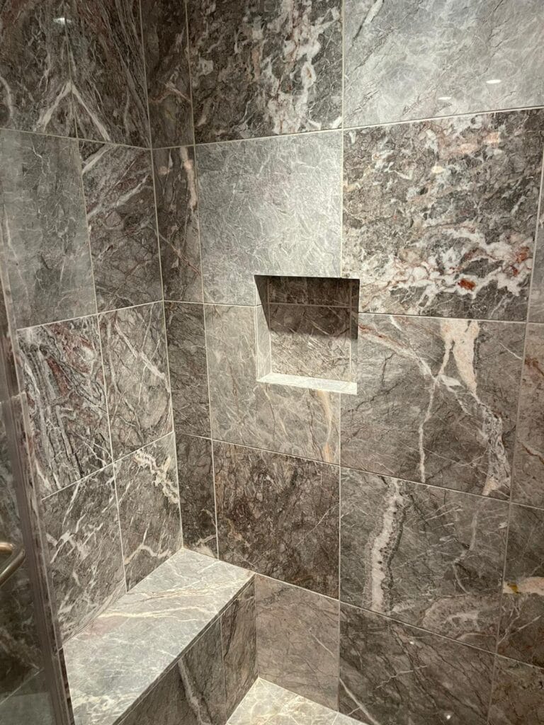 Grey marble shower walls with a niche