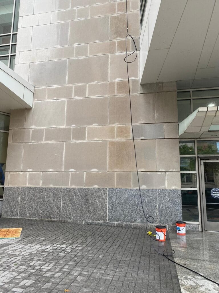 Limestone building facade partway through cleaning