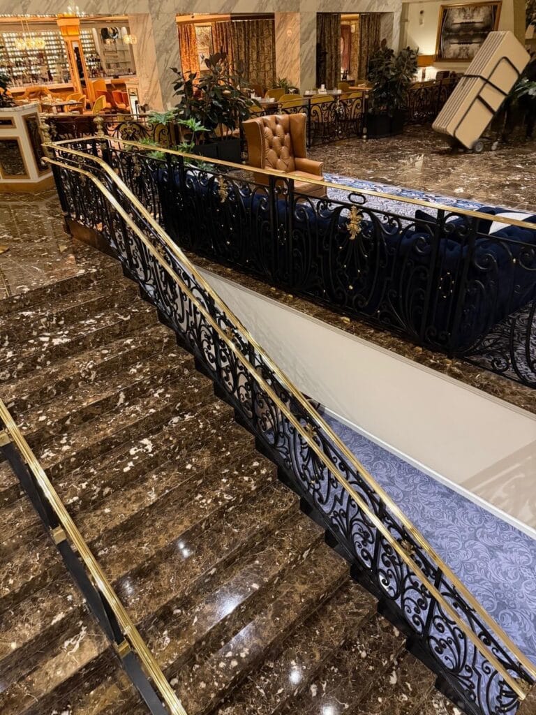 Marble stairs with ornamental iron and brass railings