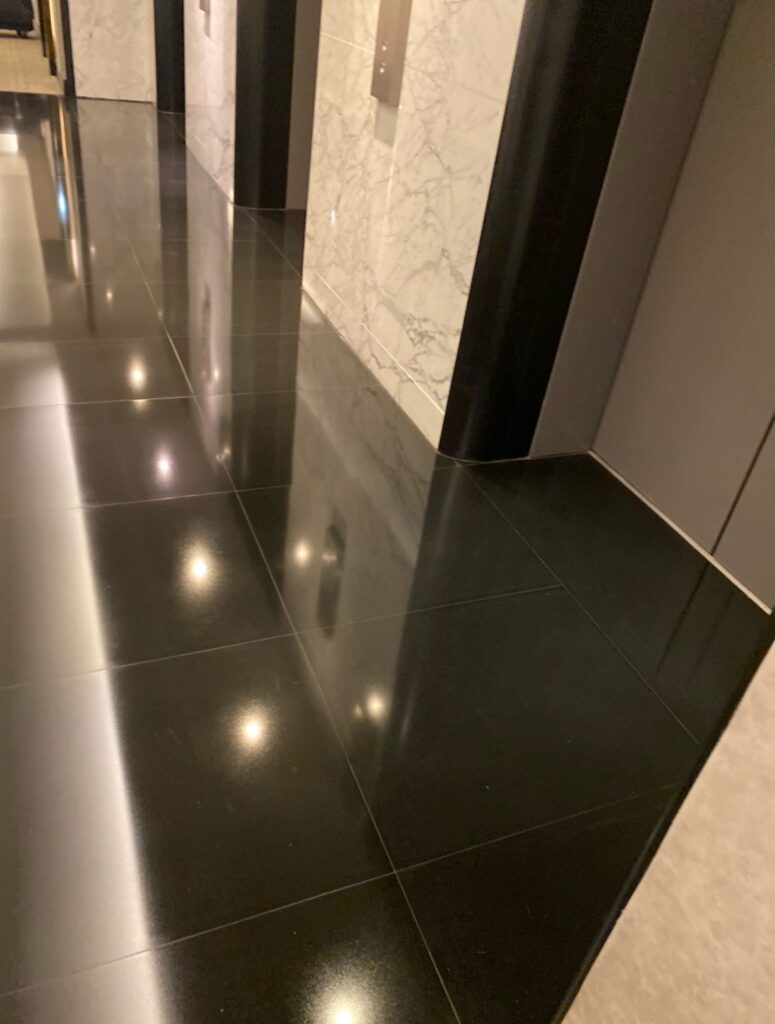 Mirror-polished black stone floor in an elevator lobby