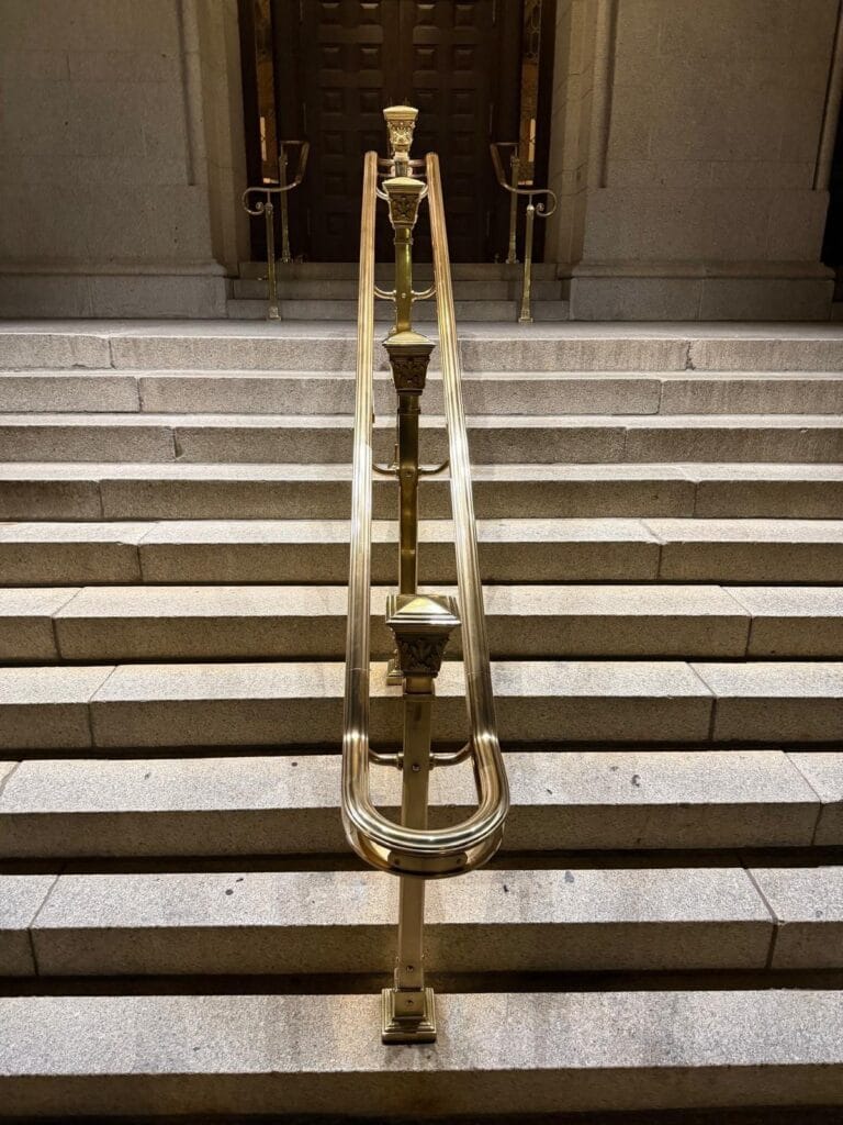 Polished brass stair handrail on the granite entrance steps of the Old Post Office building in Washington DC