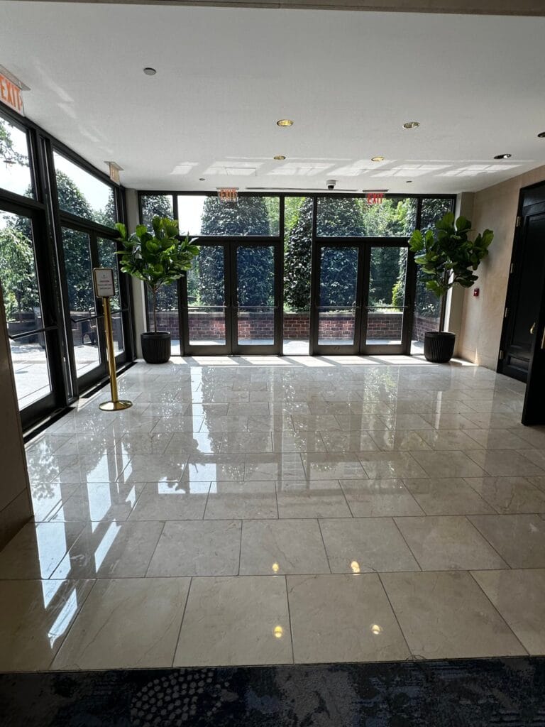 Polished marble lobby floor reflecting the entrance doors