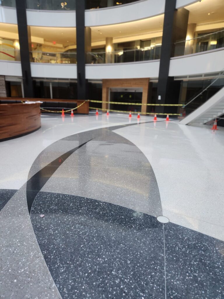 Polished terrazzo floor with a curved inlay in an atrium