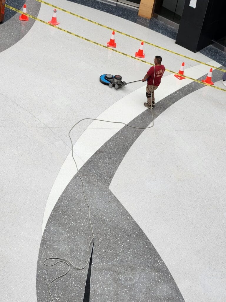 Polishing a white terrazzo floor with inlaid grey bands