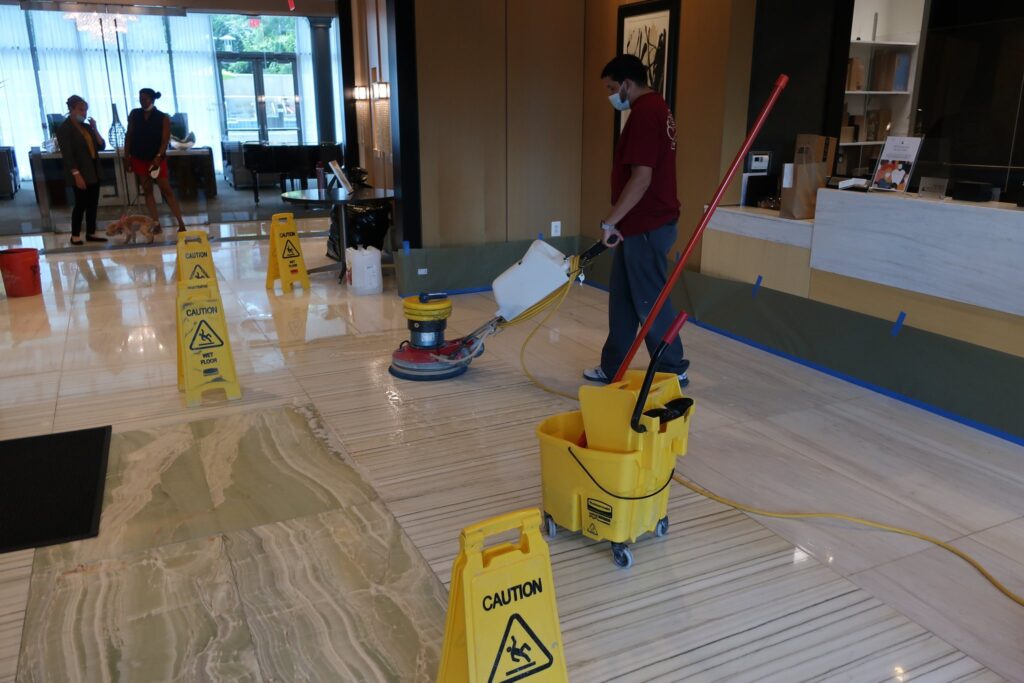Rose crew cleaning a lobby floor with warning signs out