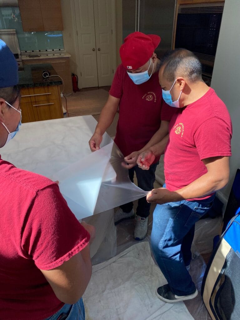 Rose crew members in red company shirts working together on a stone job