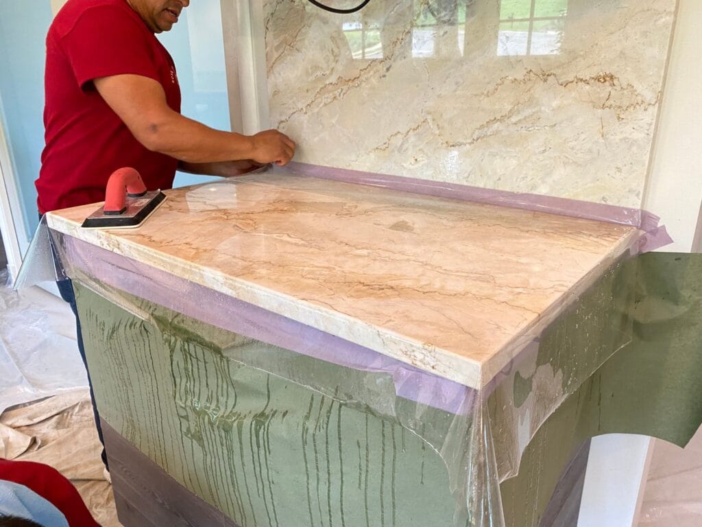 Rose technician polishing a light quartzite countertop