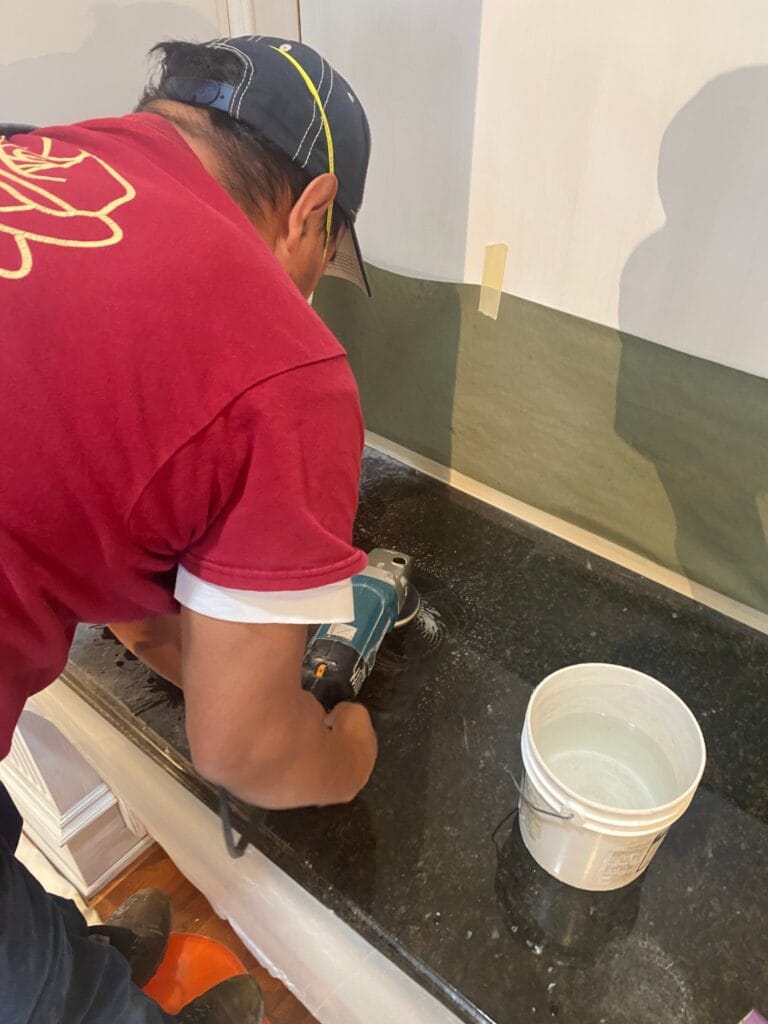 Rose technician repairing a dark granite countertop