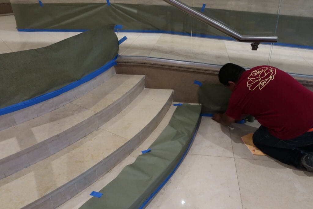Rose technician repairing stone steps under protective sheeting