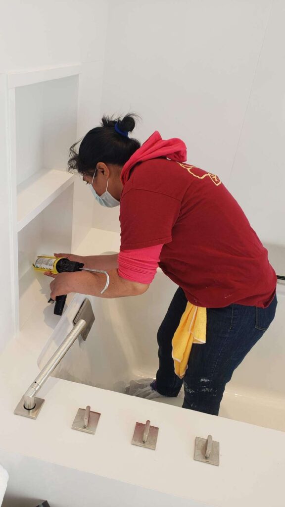 Rose technician replacing caulk around a bathtub