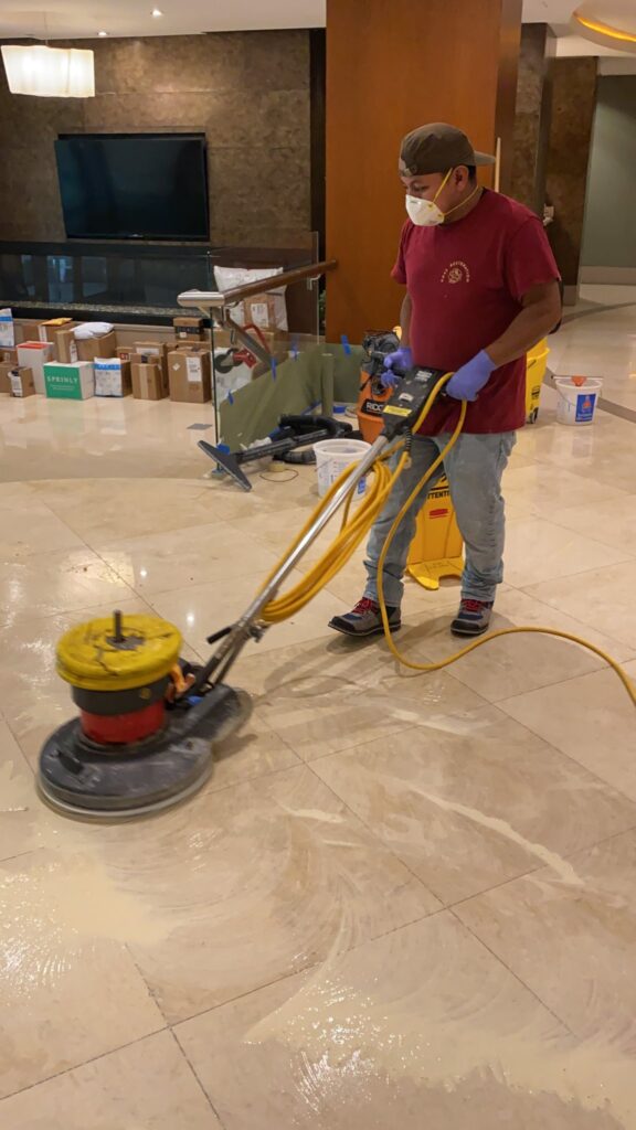 Rose technician running a floor machine on a marble lobby floor