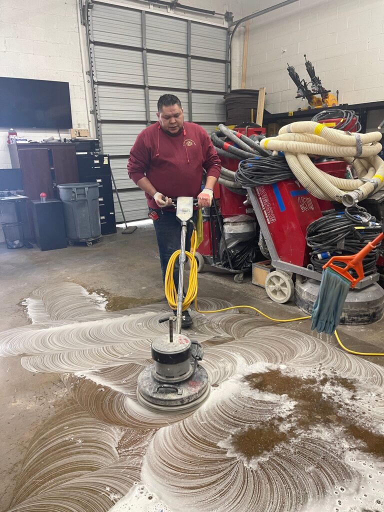 Rose technician scrubbing a stone floor with an automatic scrubber