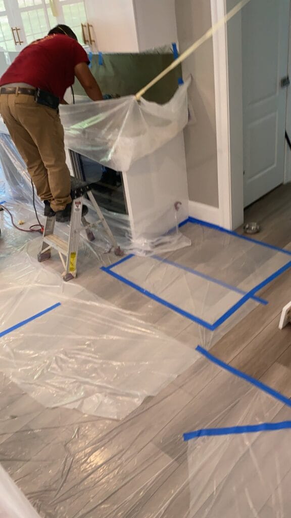 Rose technician taping protective sheeting before stone work