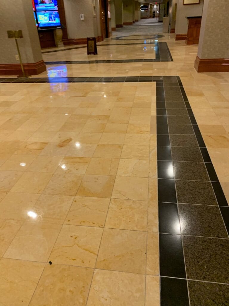 Stone corridor floor with a black granite border, polished